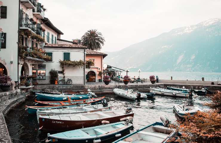 Vista del lago di Garda da un piccolo porto con barchette e case colorate