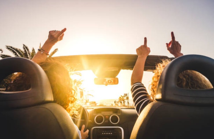 Due ragazze ascoltano musica durante il loro viaggio in macchina